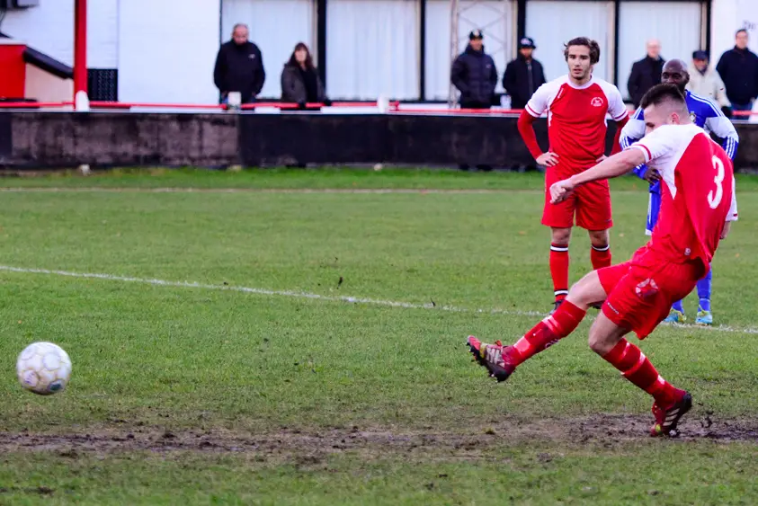 Jake White takes a penalty on a very muddy Larges Lane pitch at Bracknell Town. Photo: Neil Graham.