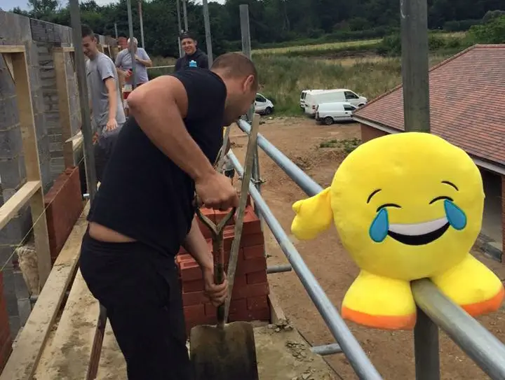 Finchampstead FC's Freddie Barron with the emoji on a building site.