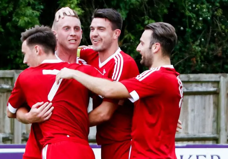 TJ Bohane mobbed by his team mates after scoring for Bracknell Town. Photo: Neil Graham.