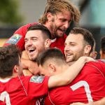 Carl Davies is mobbed after scoring for Bracknell Town. Photo: Neil Graham.