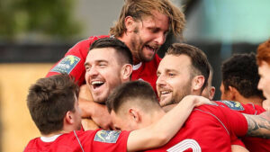 Carl Davies is mobbed after scoring for Bracknell Town. Photo: Neil Graham.