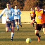 Wokingham & Emmbrook's Jake White on the ball with Woodley United's Hamilton Bowler. Photo: Peter Toft.