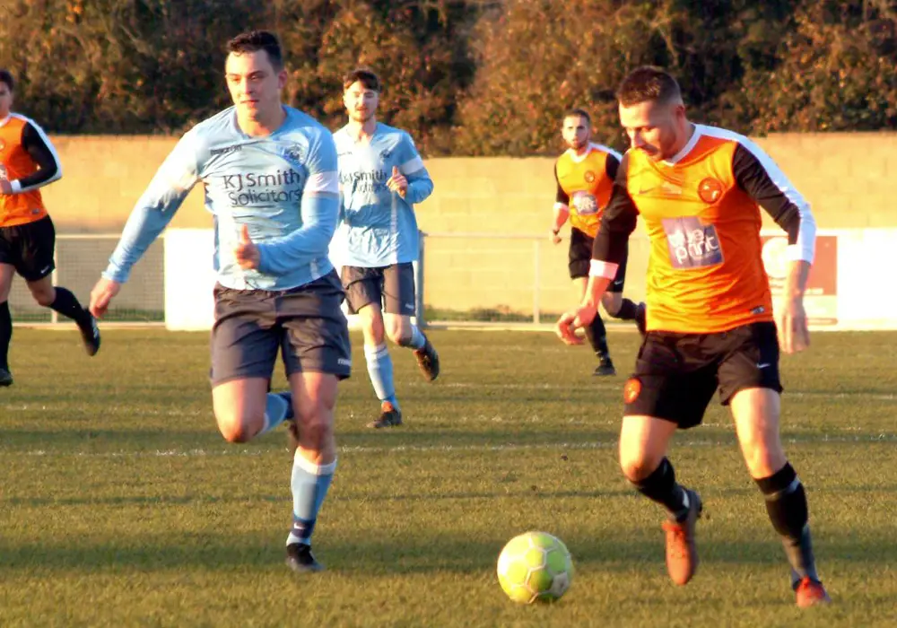 Wokingham & Emmbrook's Jake White on the ball with Woodley United's Hamilton Bowler. Photo: Peter Toft.