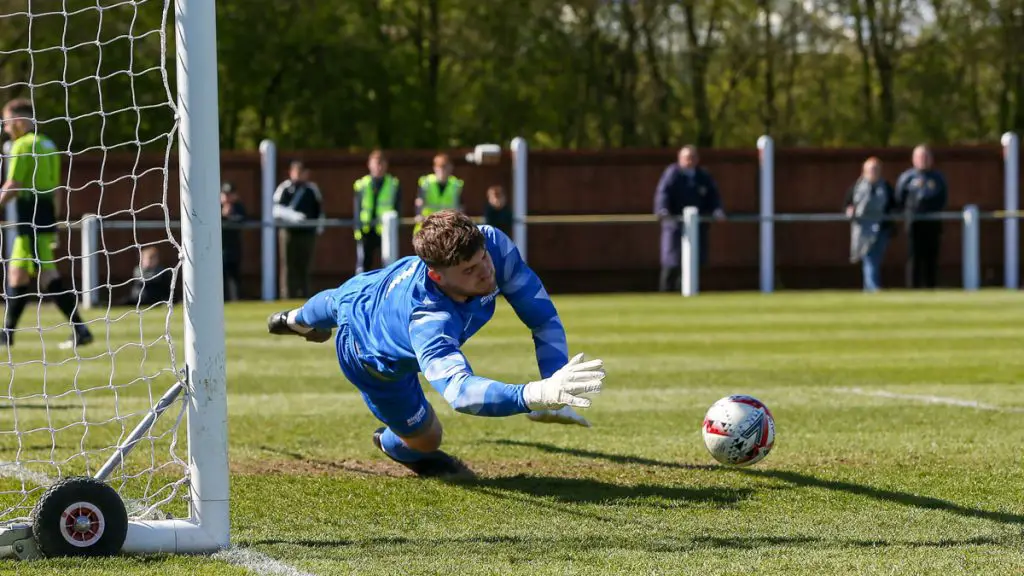 Chris Grace guesses right in the Fakenham Town v Binfield penalty shootout. Photo: Neil Graham / ngsportsphotography.com