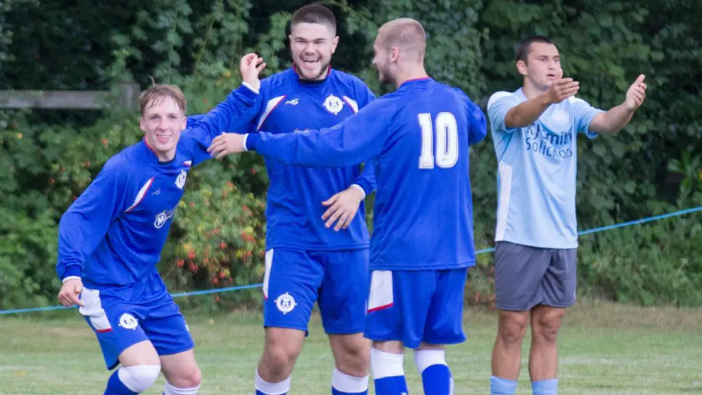 Burghfield's James McClellan is congratulated by Teo Atik and Ollie Brown. Photo: Steve Williams.