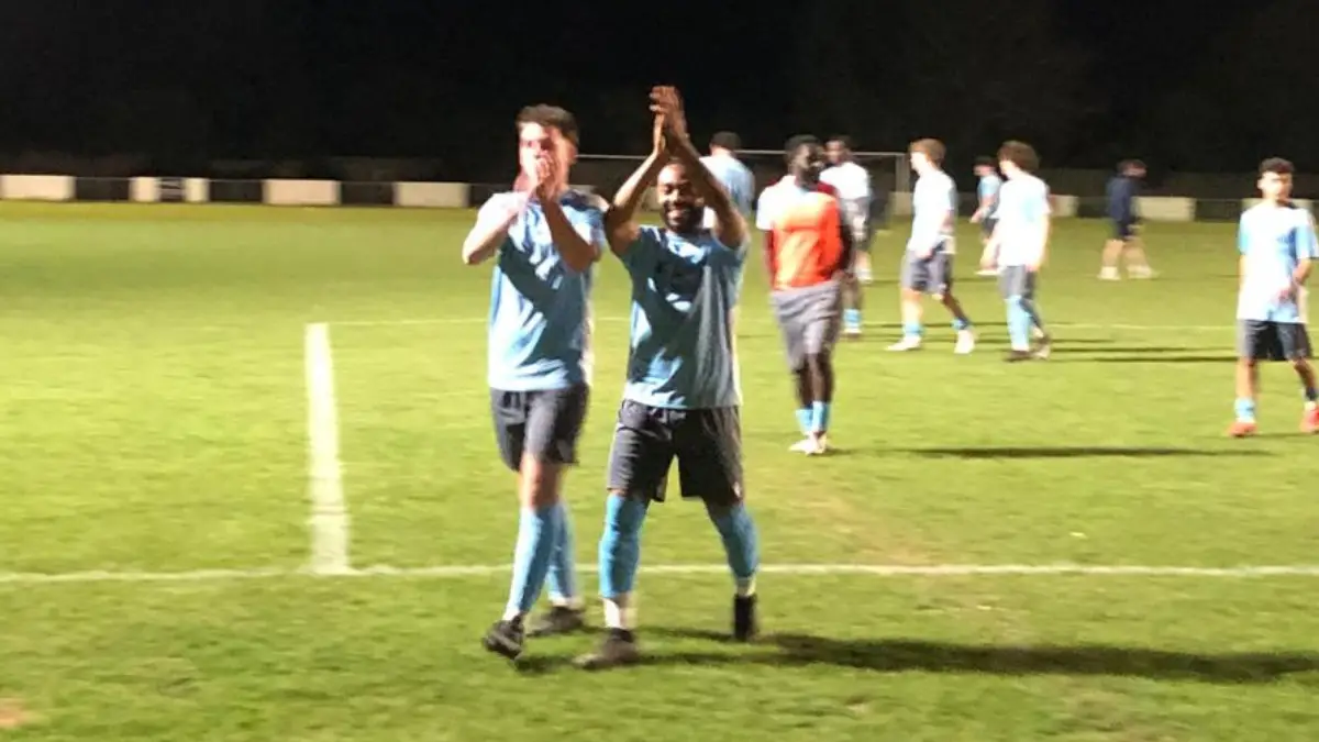 Woodley United players applaud supporters as they leave the field.
