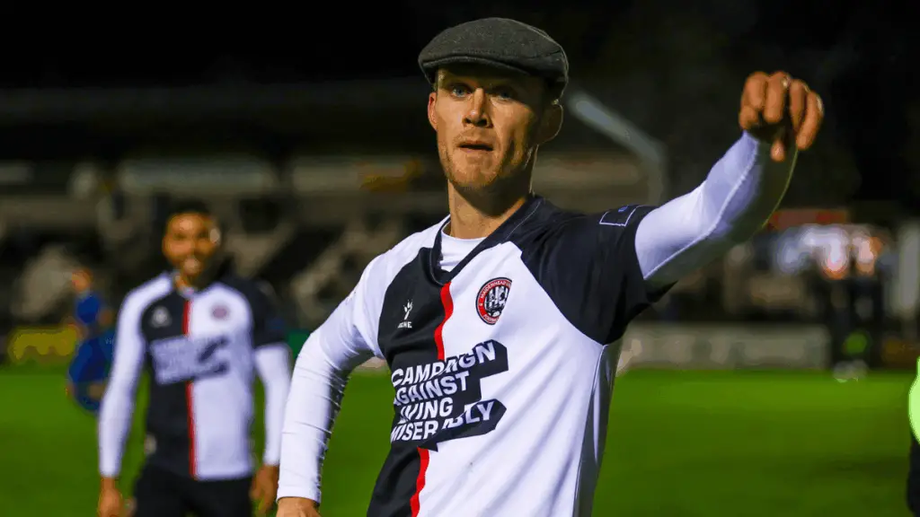 Sam Barratt plucks a flat cap from the crowd in tribute to 'Dev'. Photo: Darren Woolley.