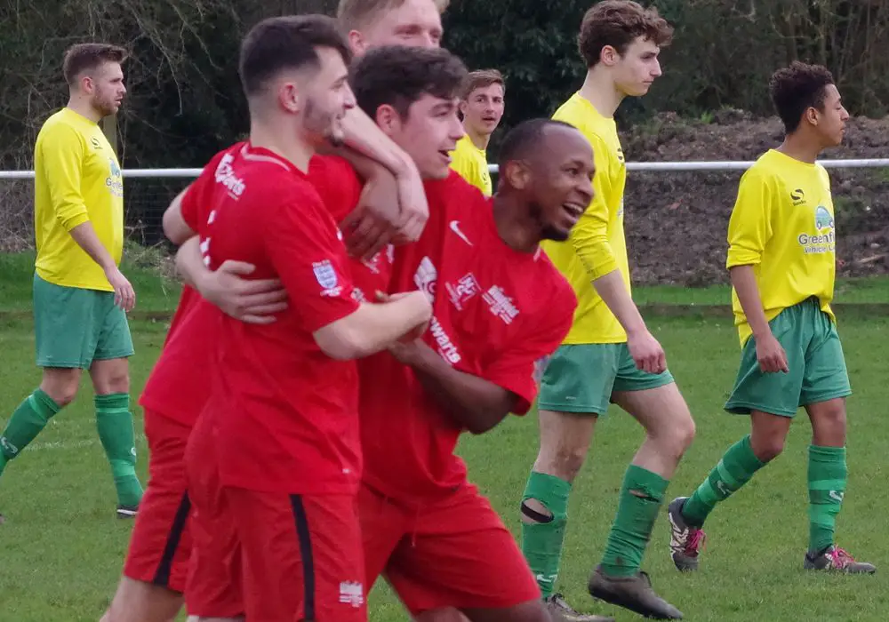 Arron Rowland is mobbed by Binfield FC teammates. Photo: James Green.