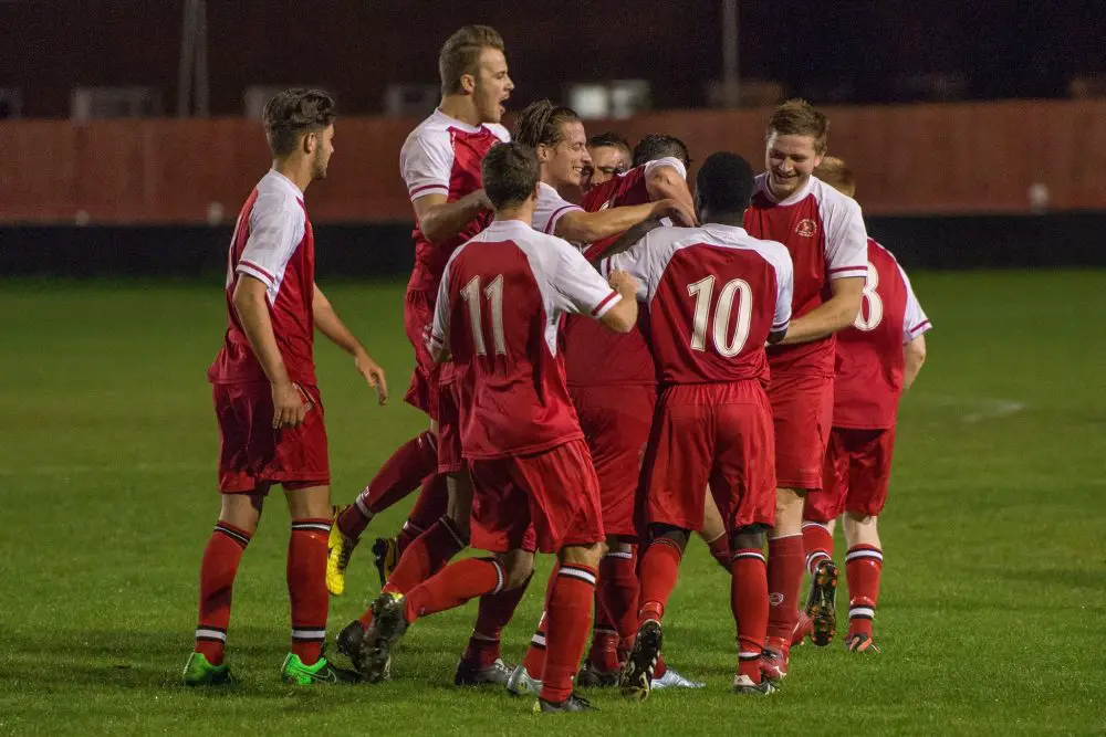 Shane Cooper-Clark is mobbed after scoring for Bracknell Town against Brimscombe & Thrupp in the Emirates FA Cup. Photo: Neil Graham.